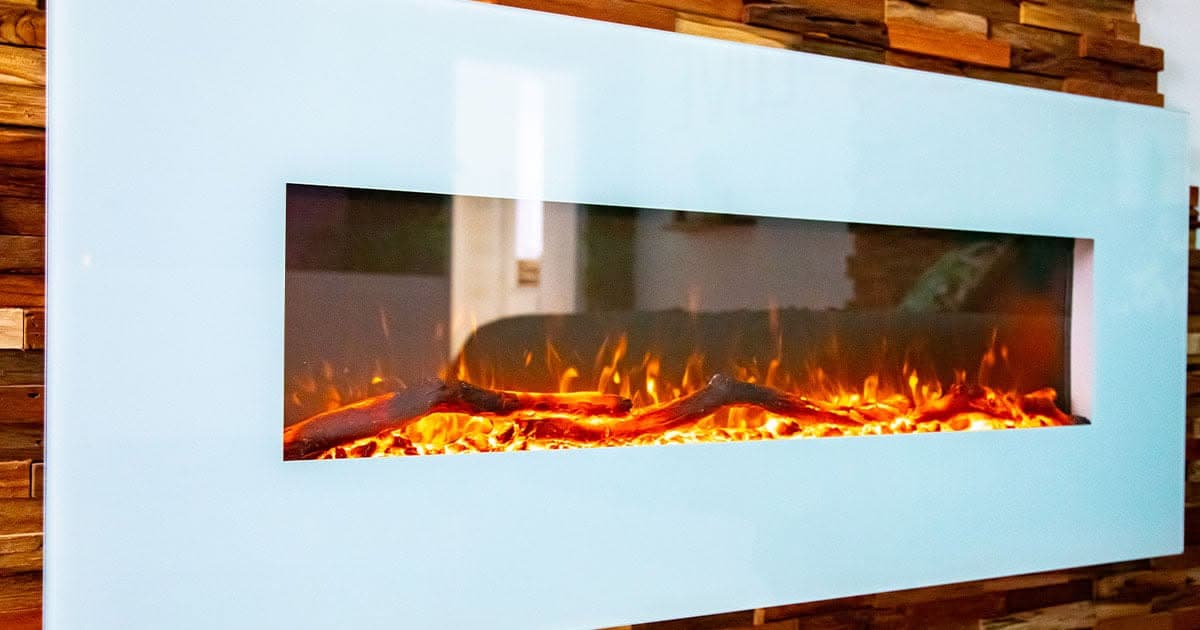 La cheminée électrique encastrée dans le mur en bois de la chambre