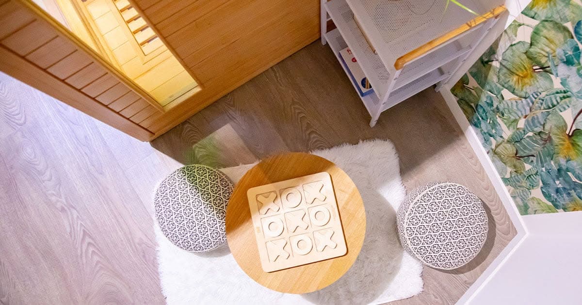 Le coin détente vu du dessus : table basse, jeu de morpion en bois et poufs