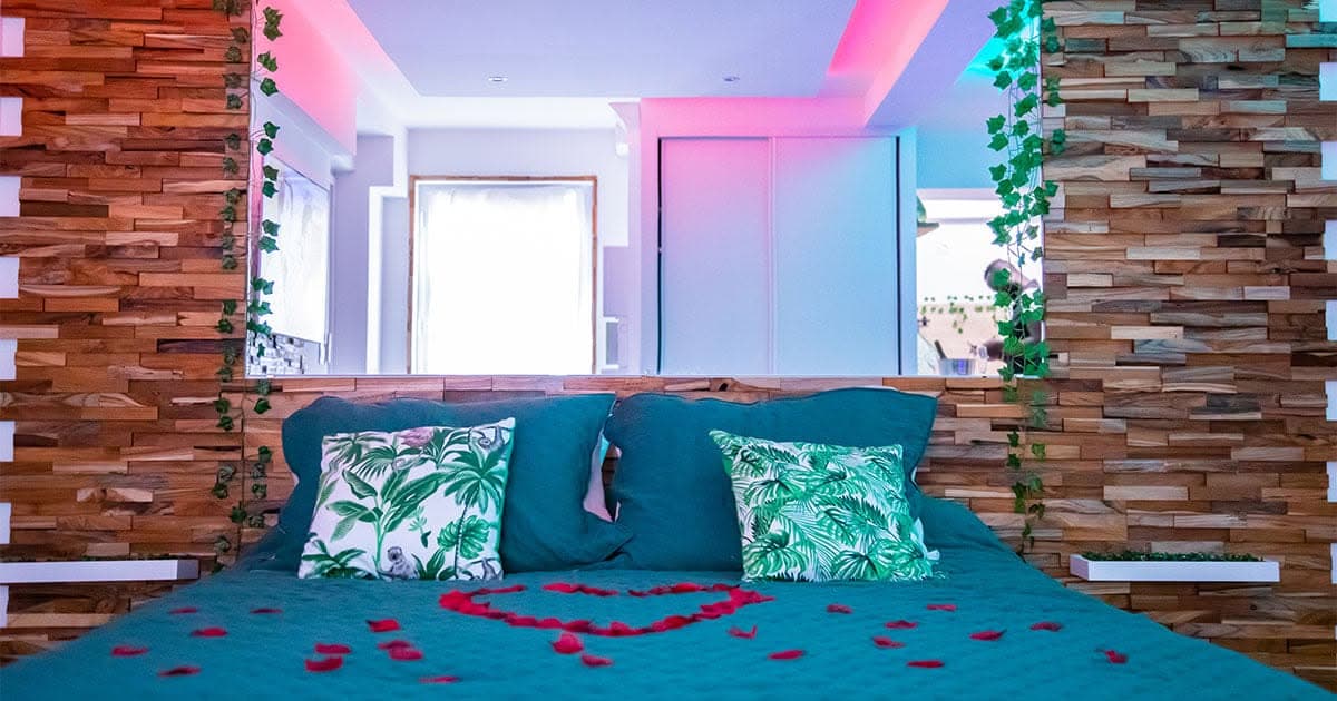 Le lit de la love room, dressé avec des pétales de rose et encadré d'un mur en bois